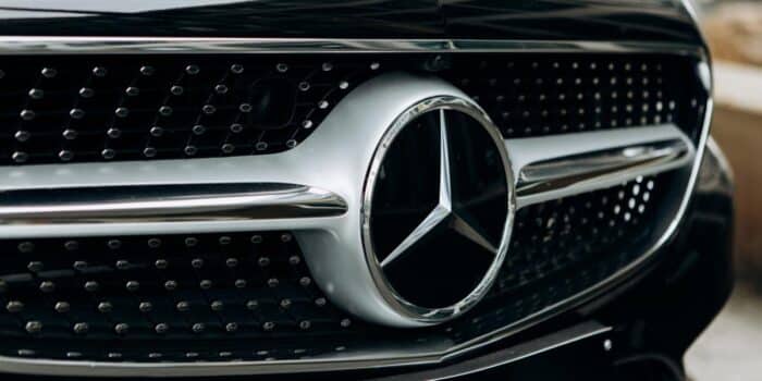 A close up to the silver Mercedes-Benz famous emblem.