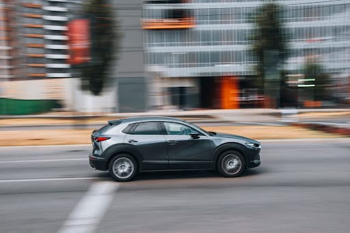 A Mazda CX-30 driving down the street in motion.