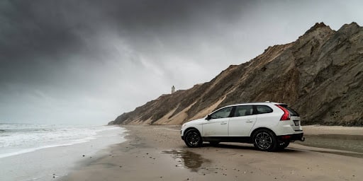 One of the safest SUVs parked in front of the beach.