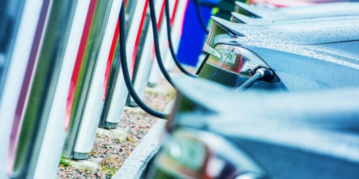 A lineup of the best hybrid sedans at a charging station.